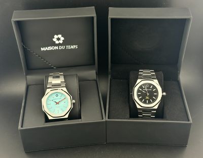 deux montres dans un coffret, avec une chaîne, posées sur une table