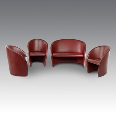 a set of three red leather chairs and a table
