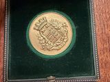 a gold coin in a green box on a table