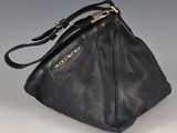 sac à main en cuir noir avec des finitions dorées et une fermeture à glissière