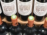 many bottles of wine sitting on a wooden stand