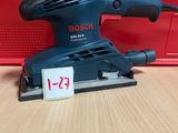 une ponceuse orbitale Bosch posée sur une table, avec son étiquette de prix