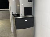 une machine à glaçons argentée et noire, dans un coin de la pièce