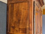 a tall wooden cabinet in the corner of a room