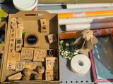 a cardboard box with stamps and other crafting supplies on a table