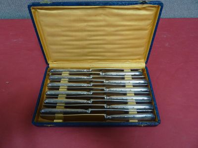 six knives in a blue case on a red table