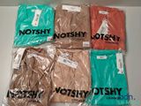 six t-shirts sont emballés dans des sacs en plastique sur une table