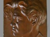 un gros plan sur une plaque en bronze représentant le visage d'un homme
