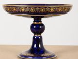 an image of a blue and gold plate on a wooden table