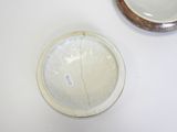 a white bowl and a brown bowl on a white table
