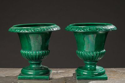 two green vases sitting on top of a table