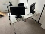 two computer monitors on a white desk in a room