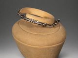 an image of a brown vase with a ring on top of it