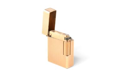 un briquet doré posé sur une surface blanche