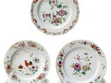 trois assiettes ornées de fleurs et d'oiseaux sur un fond blanc