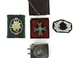 three badges and a belt buckle on a white surface