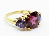 un gros plan d'une bague sertie d'une pierre violette et de pierres de tanzanite