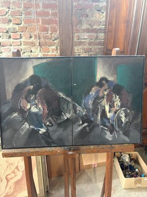 two paintings that are sitting on a easel in a room