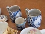a lot of dishes and cups sitting on a table