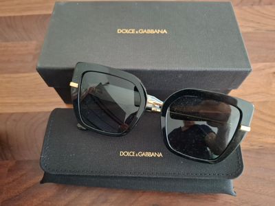 lunettes de soleil Dolce Gucci noires avec des détails dorés et des verres noirs