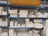 a lot of white plates and bowls on the shelves