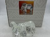 une figurine d'éléphant dans une boîte, posée sur une surface blanche