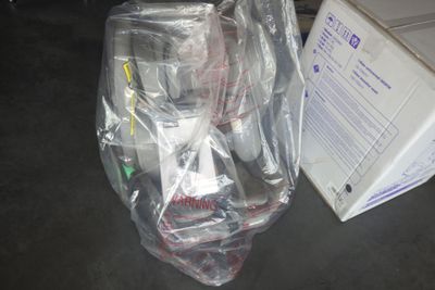 un sac en plastique posé par terre à côté d'une boîte