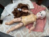 a doll that is laying on a chair with a tag on it