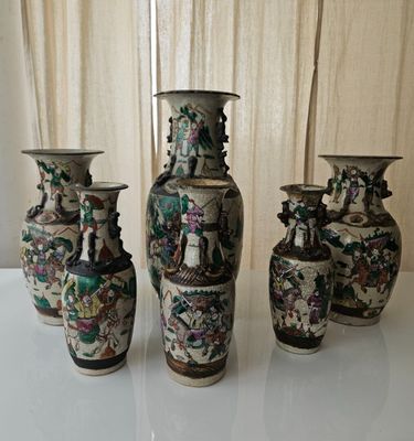 three vases sitting on a table with a curtain in the background