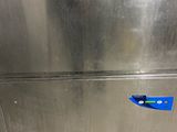 a stainless steel refrigerator with a blue sticker on it