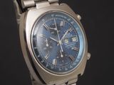 a silver watch with a blue face on a black background