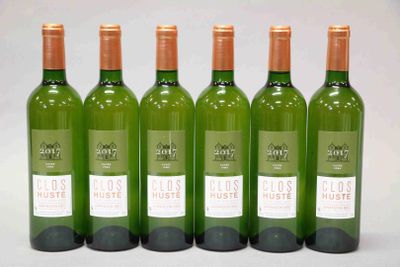 quatre bouteilles de vin sont alignées sur une surface blanche