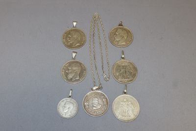 un ensemble de cinq pièces d'argent et d'or montées sur une chaîne