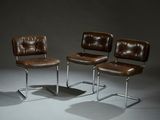 deux fauteuils en cuir marron placés l'un à côté de l'autre sur une surface grise