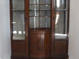 un vaisselier en bois avec des portes en verre dans une pièce