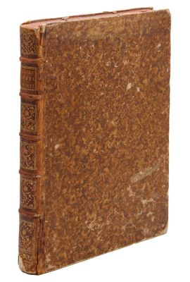 an old book with a brown cover sitting on top of a white surface