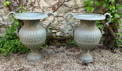 two vases sitting next to each other on the ground