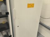 un réfrigérateur qui se trouve dans une pièce où il y a beaucoup de bouteilles