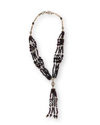 un collier de perles noires auquel est suspendu un pompon