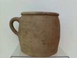a large brown pot sitting on top of a clear shelf