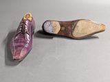 pair of purple leather shoes on a grey surface
