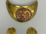 une plaque en or sur laquelle est représenté un lion, à côté de deux autres pièces d'or