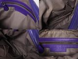 the inside of a purple purse with two zippers on it