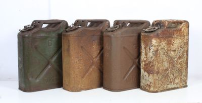 several old metal cans are lined up on a white surface
