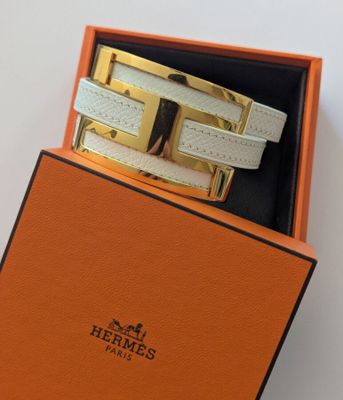 une boîte orange contenant une paire de bracelets en cuir blanc