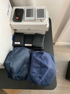 Plusieurs téléphones portables sont posés sur une table, à côté d'un sac.