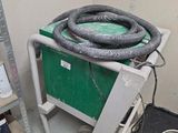 une photo d'une pièce avec un chariot vert et des outils