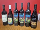 plusieurs bouteilles de vin sont alignées sur une table en bois