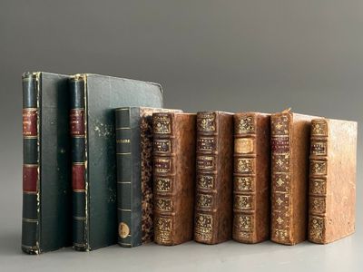 several old books are lined up in a row on a table