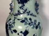 un vase bleu et blanc posé sur une surface blanche
